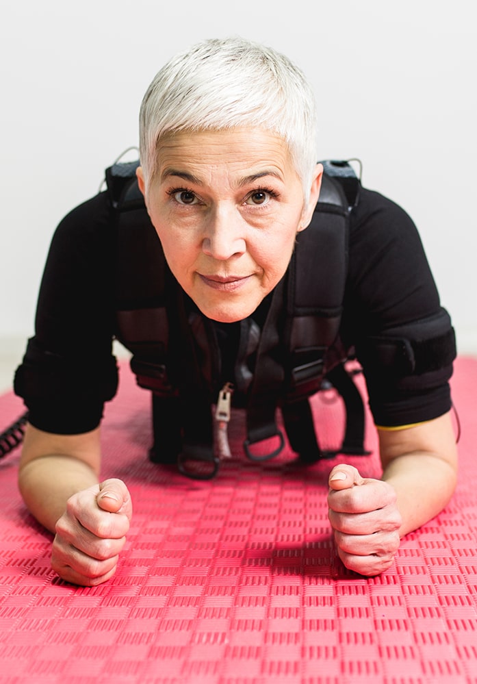 ältere frau trainiert in plank bei mybodyplace ems & personal training